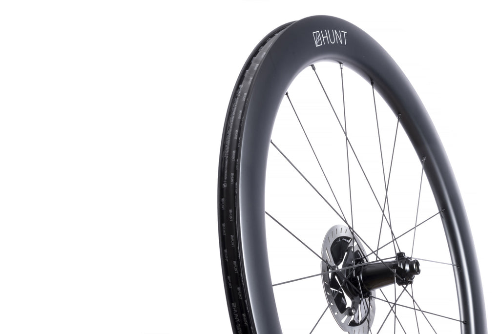 Up close image of the HUNT 54 Aerodynamicist Carbon Disc front wheel, showing the detailed rim design
