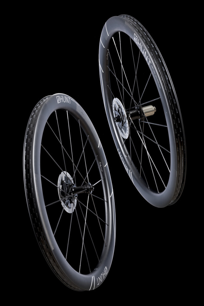 Darkened image showing the HUNT 48 Limitless UD Carbon Spoke Disc wheelset in the studio