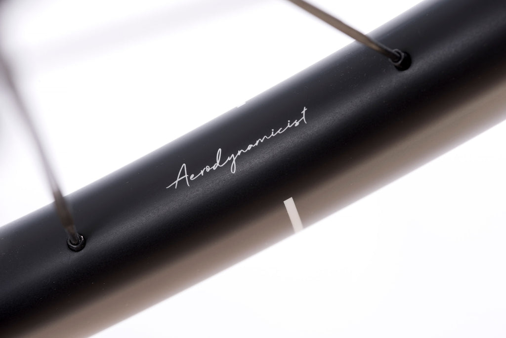 Up close shot of the subtle 'Aerodynamicist' logo on the HUNT 48 Limitless UD Carbon Spoke rim surface