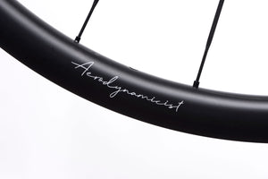 <h1>AERODYNAMICIST RIM PROFILE</h1><i>As learned from our Limitless Research project & wind tunnel time the past 3 years, an optimum aerodynamic benefit for a drop-bar bike is yielded from widening rim profiles. This allows for a far more 'blunted' spoke bed area, resulting in predictable airflow at a wider variety of wind yaw angles. The wider profile ensures the flow stays attached to the surface as long as possible before the point of separation, which is key as yaw angles increase.</i>